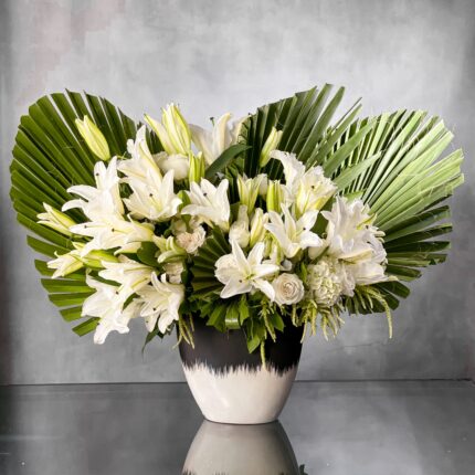 This arrangement is designed with a wealth of wondrous over 20 White Casablanca Lillies and 60 roses in an attractive modern black and white ceramic vase which adds to its beauty and sophistication. Our team at Beverly Hills Florist offers same day delivery!