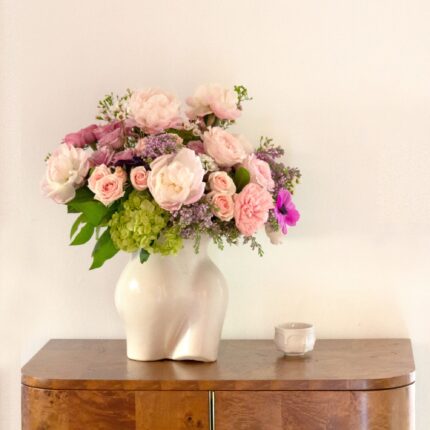 Pink and lavender blooms are a sweet and innocent way to show your affection. Beverly Hills Florist presents same day delivery four our Mademoiselle! Blooms may vary depending on the season. This arrangement features pink and lavender roses, lilacs, and pink peonies with a touch of green hydrangea in a vase that serves as an homage to the curves of the female form. Birthday flowers, Thank you flowers, thinking of you, decor flowers, Love and Romance flowers