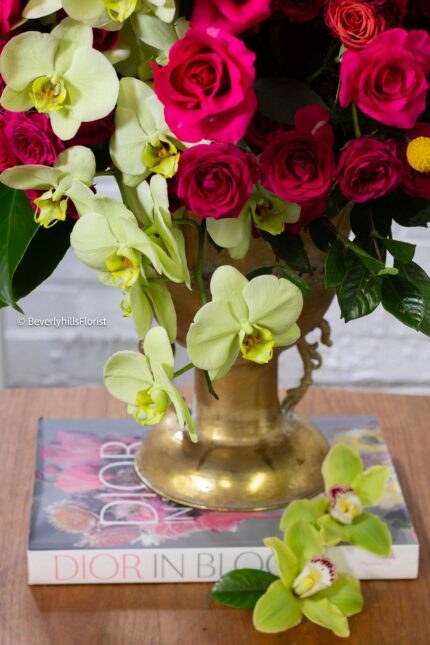 Amore Roses arrangement with red and pink Ecuadorian roses, spray roses, and orchids in a golden pedestal container, 40-inch round, elegant and romantic.
