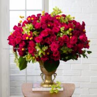 Amore Roses arrangement with red and pink Ecuadorian roses, spray roses, and orchids in a golden pedestal container, 40-inch round, elegant and romantic.