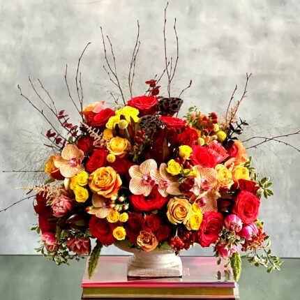 Brighten their day with this vibrant bouquet. This bouquet dashingly displays peach roses and garden roses, peach and pink orchids, yellow, red and spray roses, and pink dutch double tulips. A gorgeous mix of bold, rich and bright flowers is the best way to boost any mood and for any occasions! Overall 17x 12.