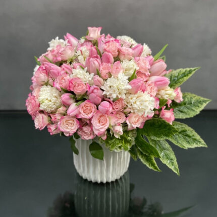 Beverly Hills Florist presents Pink Whispers for same day delivery! Soft pink and arrangement consists of pink tulips, pink spray roses, hyacinths with light green hydrangeas nested in a beautiful ceramic vase. This arrangement will add a delicate touch of beauty to any room. Depending on the season, various blooms maybe substituted.