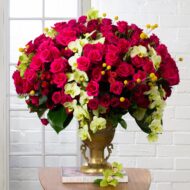 Amore Roses arrangement with red and pink Ecuadorian roses, spray roses, and orchids in a golden pedestal container, 40-inch round, elegant and romantic.